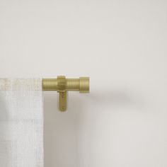 an open curtain with a gold metal handle on the side and white curtains behind it