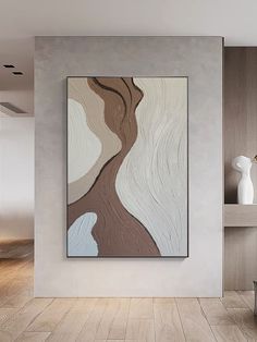 an abstract painting hangs on the wall next to a vase and lamp in a modern living room