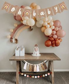 a baby shower party with balloons, cake and streamers on the wall above a table