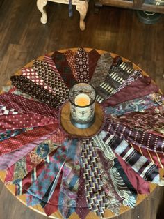 a wooden table topped with lots of different types of ties and a candle on top of it