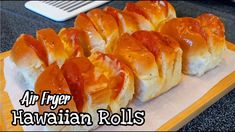 several rolls covered in ketchup on top of a cutting board with the words air fryer hawaiian rolls