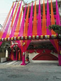 an orange and pink building with lots of sheer curtains on the front entrance to it