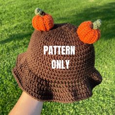 a hand is holding a knitted hat with two pumpkins on it that says pattern only