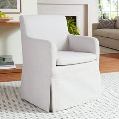 a white chair sitting in front of a fireplace