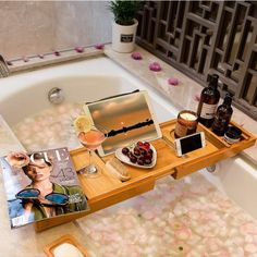 a bath tub filled with lots of soap and bottles next to a magazine on top of it