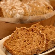 two pieces of bread sitting on top of a white plate next to a brown paper bag