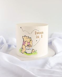 a winnie the pooh mug sitting on top of a bed