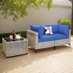 a blue couch sitting on top of a wooden floor next to a table and chair