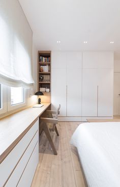 a bedroom with white walls and wooden floors