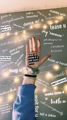 a person with their hand up in front of a wall that has words all over it