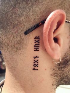 a man with a tattoo on his ear has the word xxvi written in roman numerals