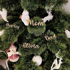 a christmas tree with ornaments on it and the word mom dad written in gold letters