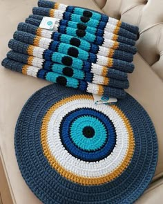 two crocheted rugs sitting on top of a couch next to each other