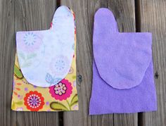 two oven mitts sitting next to each other on top of a wooden fence covered in fabric