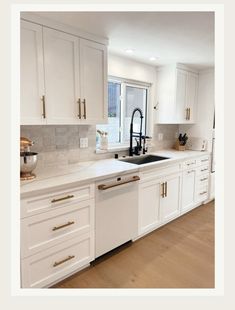 a kitchen with white cabinets and gold pulls on the handles, an island sink and a dishwasher