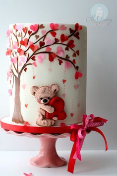 a cake with a teddy bear holding a heart