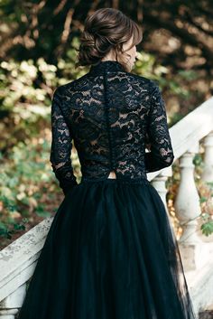 a woman in a black dress standing on stairs