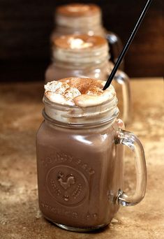 three mason jars filled with hot chocolate and marshmallows