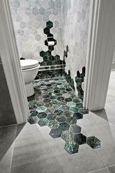 a bathroom with hexagonal tiles on the floor and walls in black and white