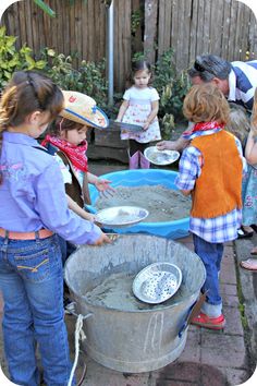 several children are playing with sand in a bucket