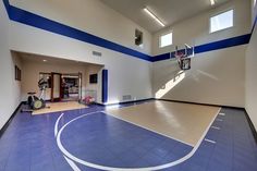 an indoor basketball court with blue and white paint