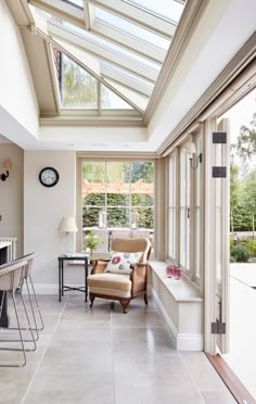 a living room filled with furniture next to a kitchen and dining room table under a skylight