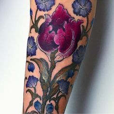 a close up of a person's leg with flowers on it