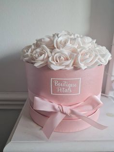 a pink hat with white roses in it