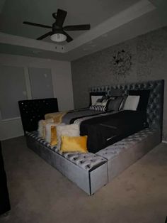 a large bed sitting in the middle of a bedroom next to a wall mounted ceiling fan