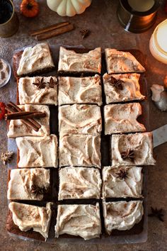 pumpkin spice brownies cut into squares and placed on a cutting board with cinnamon sticks