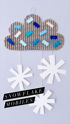 paper snowflake mobiles are hanging from strings on a string with the words snowflake mobiles below them