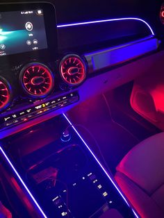 the interior of a car is lit up with red and blue lights as well as electronic controls