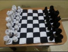 a chess board made out of legos and black and white pieces on a table