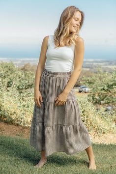 Perfectly printed, this stunning skirt will turn heads with every wear. The Olinda Skirt is a beautifully tired midi skirt with a neutral gingham pattern. This skirt features pockets and an elastic waistband. S: 34” Length / 27” (38” stretched) Waist M: 34” Length / 29” (40” stretched) Waist L: 34.5” Length / 32” (42"