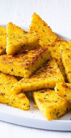 a plate full of cheesy bread sticks on a white tablecloth covered table