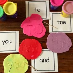 four pieces of paper with the words love and joy on them sitting in front of some crafting supplies