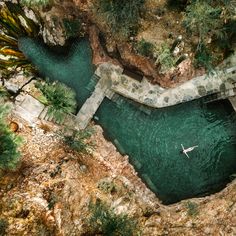 an aerial view of a man in a kayak on the water