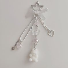 a keychain with a teddy bear charm attached to it's side on a white surface