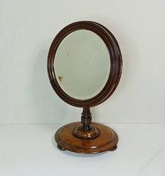 an old fashioned wooden mirror sitting on top of a table