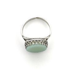 a silver ring with a green stone on it's center and filigrees around the band