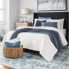 a bed with blue and white comforters in a bedroom