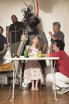 a group of people sitting around a table with an object on it's side