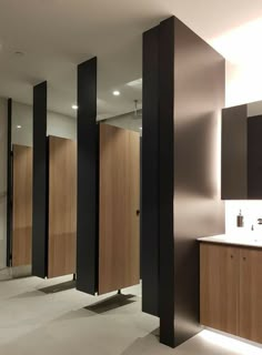 an empty bathroom with wooden stalls and sinks