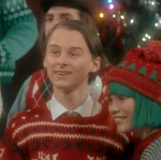 a group of people wearing ugly sweaters and hats