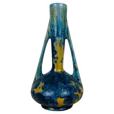 a blue and yellow vase sitting on top of a table