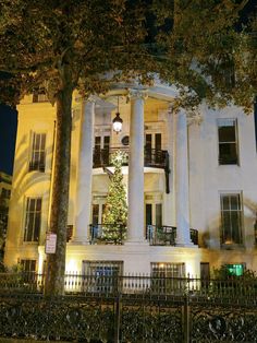 a large white building with a christmas tree on the front and balconies above it