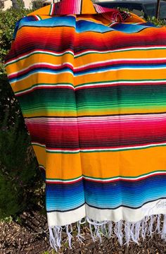 a colorful blanket sitting on top of a wooden bench