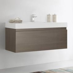 a bathroom with a sink, mirror and towel dispenser on the wall