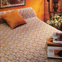 an orange and white bedspread on a bed in a bedroom