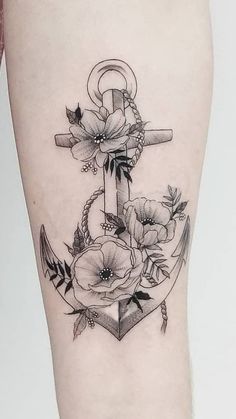 an anchor with flowers on the side of her leg is shown in black and white